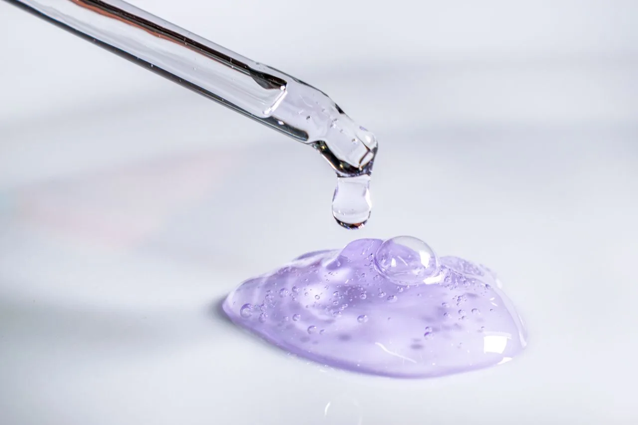Crafting Captivating Headlines: Your awesome post title goes here Pipette releasing drop of purple gel, highlighting skincare and laboratory use.